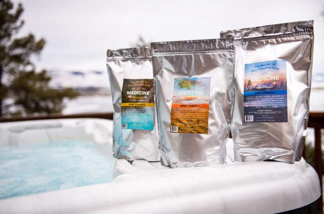 Three pouches of Medicine Springs product. These are the Joint Formula, Sport Formula and Skin Formula mineral therapy sitting on the edge of a hot tub.