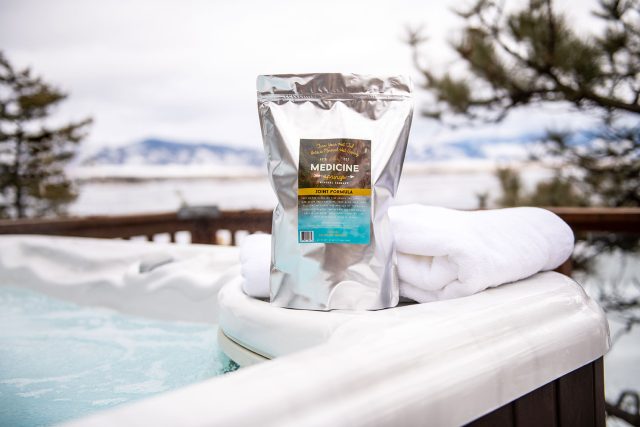 A pouch of Medicine Springs joint formula mineral therapy product sitting on the edge of a hot tub.