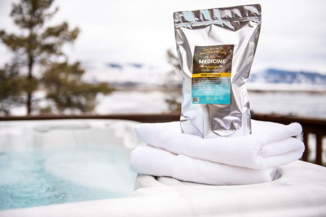 A pouch of Medicine Springs Joint Formula mineral therapy product sitting on the edge of a hot tub.